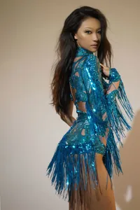 Dettaglio laterale di un mini abito blu con paillettes e lunghi accenti di frange