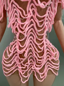 Close-up view of a pink plush textured evening dress featuring rhinestone chain details.