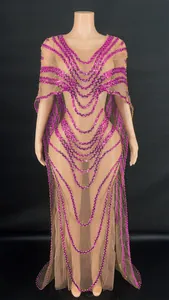 Exquisite detail of nude mesh evening gown featuring purple sequins and an elegant cape design
