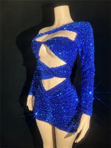 Detail of royal blue sequined mini dress with cutout design and one-shoulder style.