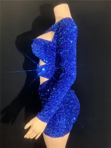 Detailed side view of a shimmering blue sequin mini dress with cut-outs on a mannequin.
