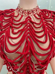 Detail of a red rhinestone evening dress with velvet wavy patterns and mesh base