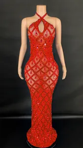 Close-up of a sparkling red halter dress with mesh fabric and teardrop rhinestones.