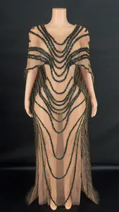 Elegant long mesh gown featuring a cape design and ornate black gold sequin tiers