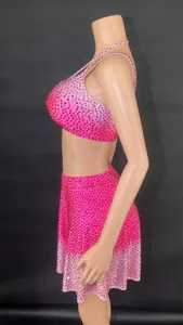 Detailed side view of pink rhinestone two-piece dance set with crop top and skirt