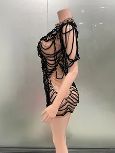 Side view of avant-garde nude mesh dress with black cords and silver chains