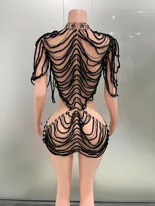 Close-up back view of exotic designer stage dress with black wave rope detailing on nude fabric