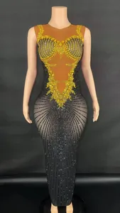 Close-up detail of elegant black mesh performance gown with yellow rhinestone patterns