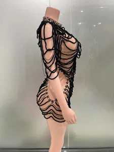 Detailed view of personalized black string evening dress with chain and bead embellishments