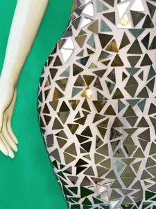 Close-up detail of golden triangular mirror sequins on a luxury mesh evening dress
