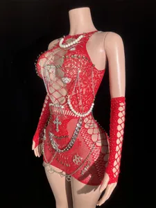 Detailed view of red fishnet mini dress with punk style chain and safety pin decor