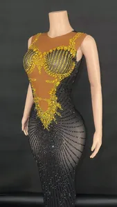 Close-up detail of a glamorous floor-length gown with intricate yellow and black rhinestones