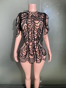 Detailed view of a black wavy mesh nightclub performance dress on a mannequin.