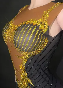 Detailed close-up of sparkling yellow and black rhinestones on a mesh performance dress