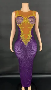 Close-up view of elegant purple evening gown featuring intricate gold rhinestone patterns.