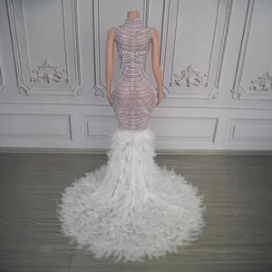 Detailed back view of luxury rhinestone and white feather mermaid evening gown train