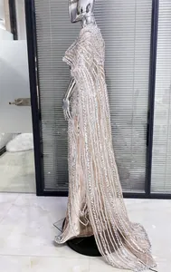 Side view of silver sequin embellished nude evening gown with long cape sleeves.