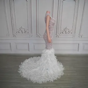 Luxurious mermaid evening gown with sparkling crystals and a grand white feather train