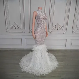 Detailed view of a luxury mermaid gown with shimmering diamonds and white ostrich feathers.
