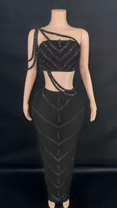 Black two-piece set featuring rhinestone tube top and bodycon maxi skirt detail