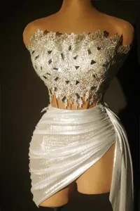 Detail view of silver sequined off-shoulder mini top and pleated high-waisted skirt set