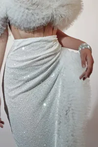 Exquisite Detailansicht des weißen Pailletten-Minirocks mit eleganter Drapierung und Rüschen