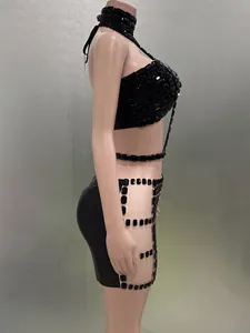 Seitenansicht eines schwarzen Sets aus Neckholder-Top und Minirock mit Strasssteinen.