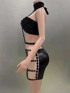 Seitenansicht eines schwarzen Neckholder-Tops mit Strass und passendem Minirock.