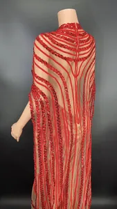 Macro view showing the intricate red sequin patterns on a sheer mesh cape sleeve dress