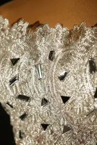 Close-up detail of silver lace and reflective sequins on a fashionable mini top