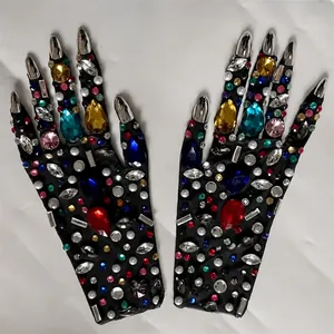 Vista dettagliata dei guanti con strass multicolori e unghie a artiglio d'argento