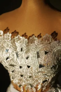Detail of elegant silver lace embroidery and sequins on an off-the-shoulder top