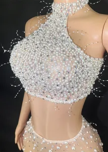 Gedetailleerd overzicht van witte parels en strassteentjes op een halter-partytop.