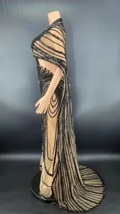 Side view of sexy nude mesh bodycon dress with black sequins and cape sleeve.