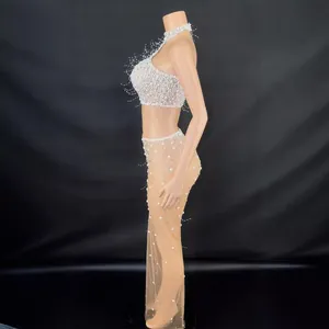 Zijaanzicht van elegante haltertop en rokset met parels en strass voor podiumfeesten