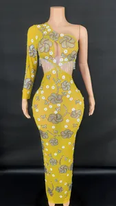 Détail d'une robe de soirée jaune asymétrique avec motifs floraux en sequins