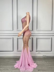 Side profile of a sparkling pink mermaid dress with intricate beadwork and mesh panels.