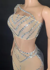 Close-up of sparkling rhinestone embellishments on nude mesh crop top and skirt set