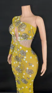 Détail montrant le motif floral en strass sur une robe de soirée jaune à une épaule