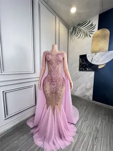 Detailed view of the pink rhinestone mermaid evening gown with a matching floor-length cape.