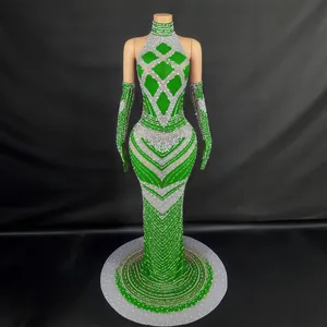 Elegante vestido de noche verde con cuello halter, lentejuelas y guantes largos a juego.