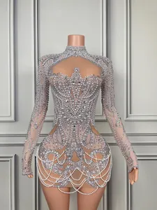 Intricate detail of rhinestone and pearl beaded long-sleeved mini dress with high neck