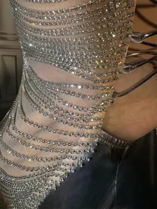 Detailaufnahme eines silbernen Ballkleids mit funkelnden Strassfransen und Netzgewebe