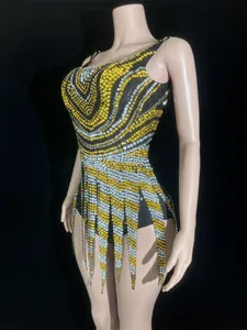 Detail view of sparkling yellow and silver rhinestone patterns on a backless mini dress.