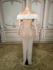 Back view of elegant nude mesh evening gown with rhinestones and white rose trim