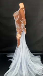 Detailed side view of luxury stage dress with white rhinestones and long blue mesh train