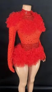 Detail showing red rhinestone bodysuit with dramatic ruffled tulle shoulders and waist