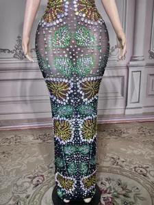 Detail view showing sheer black fabric and intricate colorful rhinestone patterns on a dress