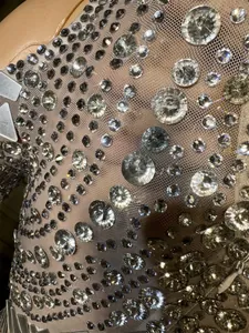 Primo piano di strass e cristalli scintillanti su un abito in tessuto a rete nuda