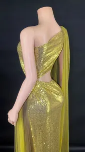 Close-up of gold one-shoulder sequin evening gown with sexy backless hollow design.